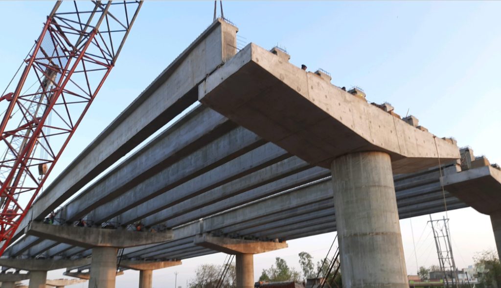 Precast bridge segment being placed on a highway project